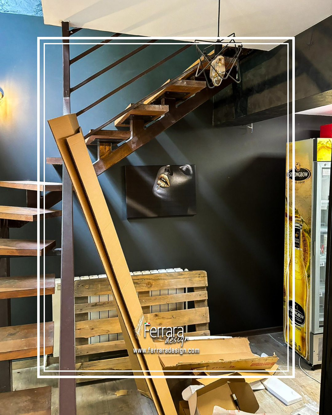 Wooden staircase with metal railing against a dark wall, featuring a Ferrara Design logo.