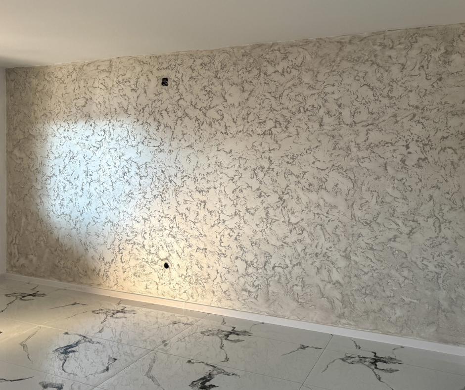Wall with textured wallpaper and a light fixture casting a shadow.