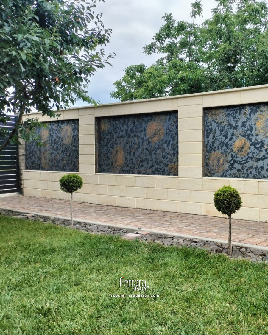 A modern outdoor wall feature with three large rectangular panels covered in a dark blue and gold abstract pattern, mounted on a beige tiled wall above a paved walkway and green lawn.