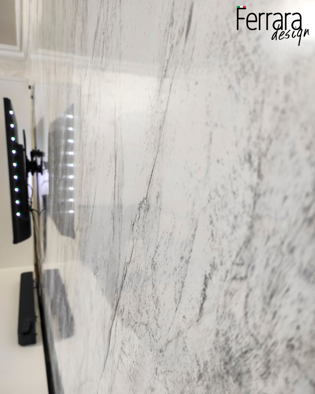 Close-up of a marble countertop with 'Ferrara Design' branding.