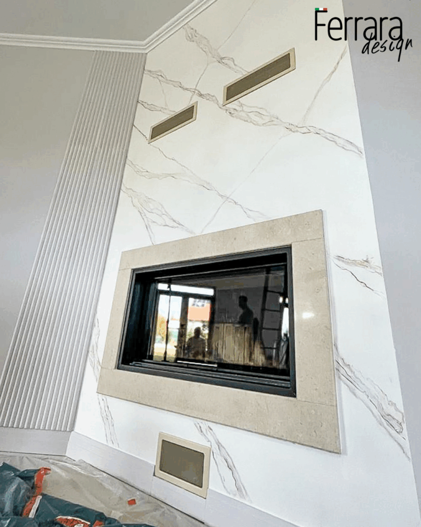 Modern fireplace with marble surround and 'Ferrara design' branding.